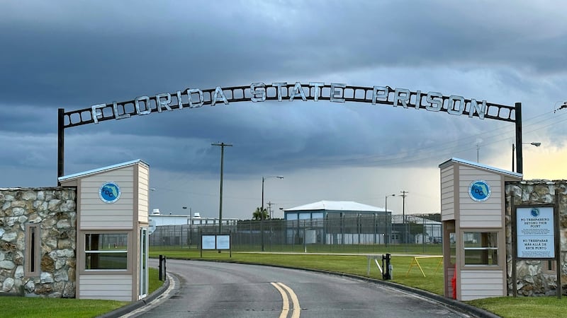 FILE - Clouds hover over the entrance of the Florida State Prison in Starke, Fla., Aug. 3,...