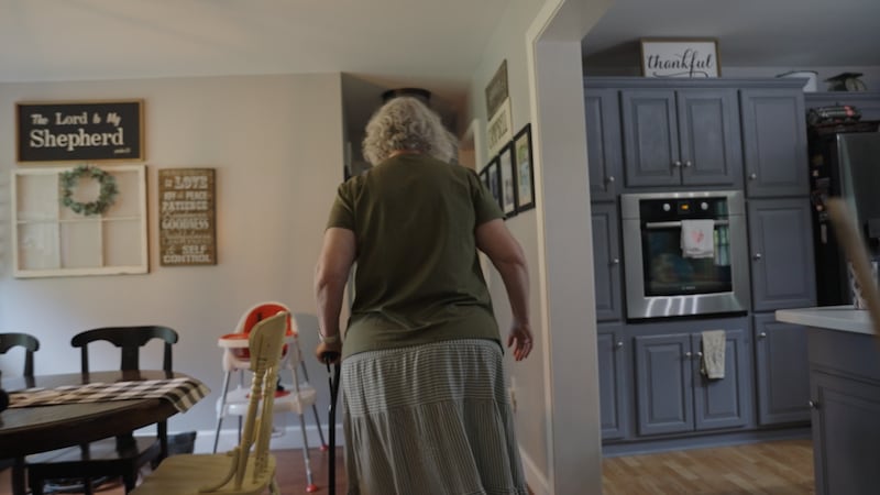 Stephanie Campbell takes a short walk in her home as she recovers from hip replacement surgery