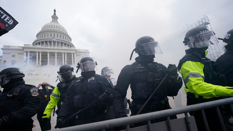 FILE - Police stand guard after holding off rioters who tried to break through a police...