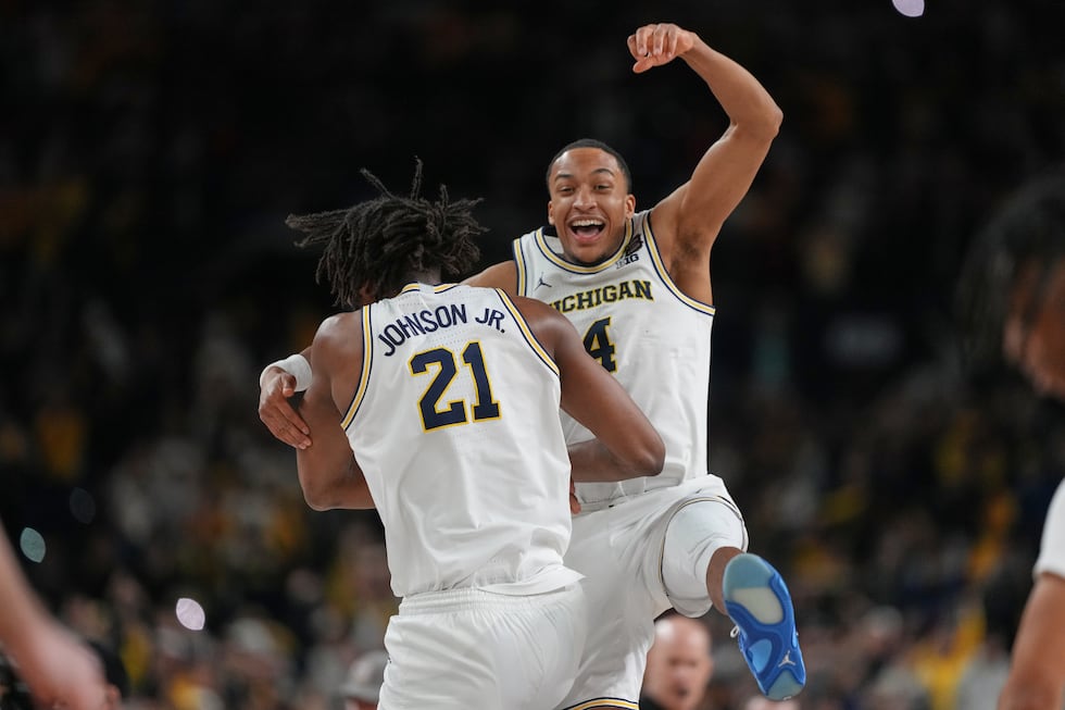 Michigan's Nimari Burnett (4) and Morez Johnson Jr. celebrate after defeating UConn in the...